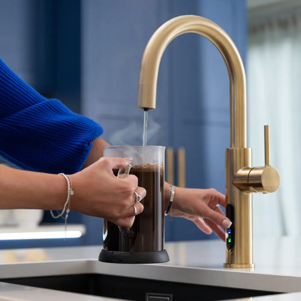 A Person Pouring Boiling Water From A Tap Into A Cafetiere