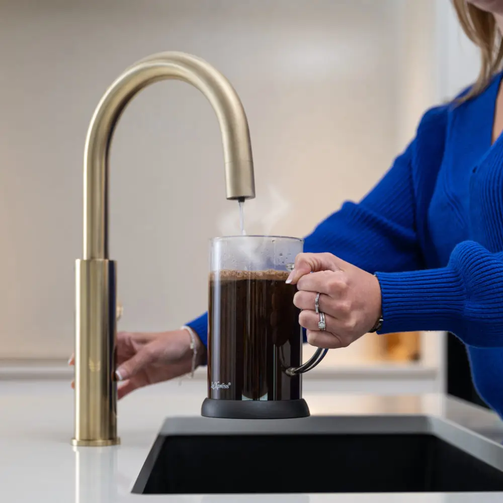 A Person Pouring Boiling Water From A Tap Into A Cafetiere