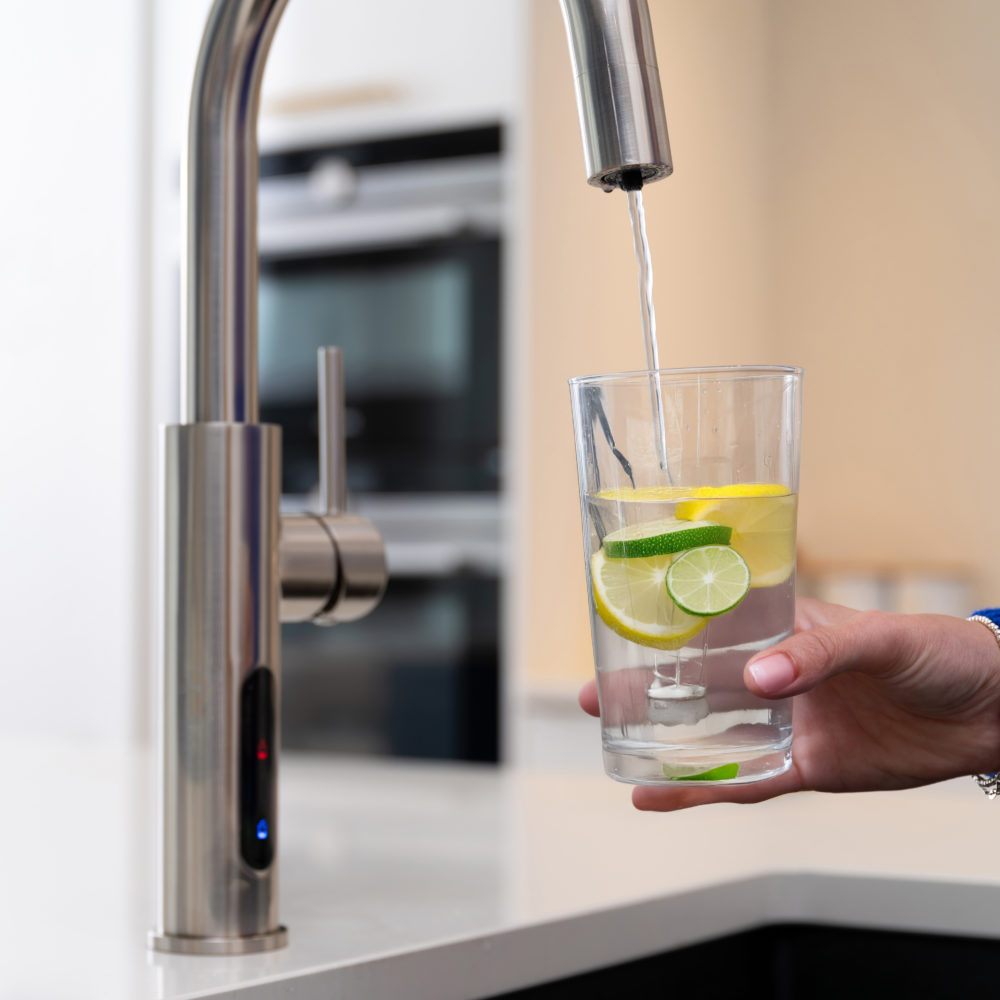 A Person Pouring Filtered Water Into A Glass