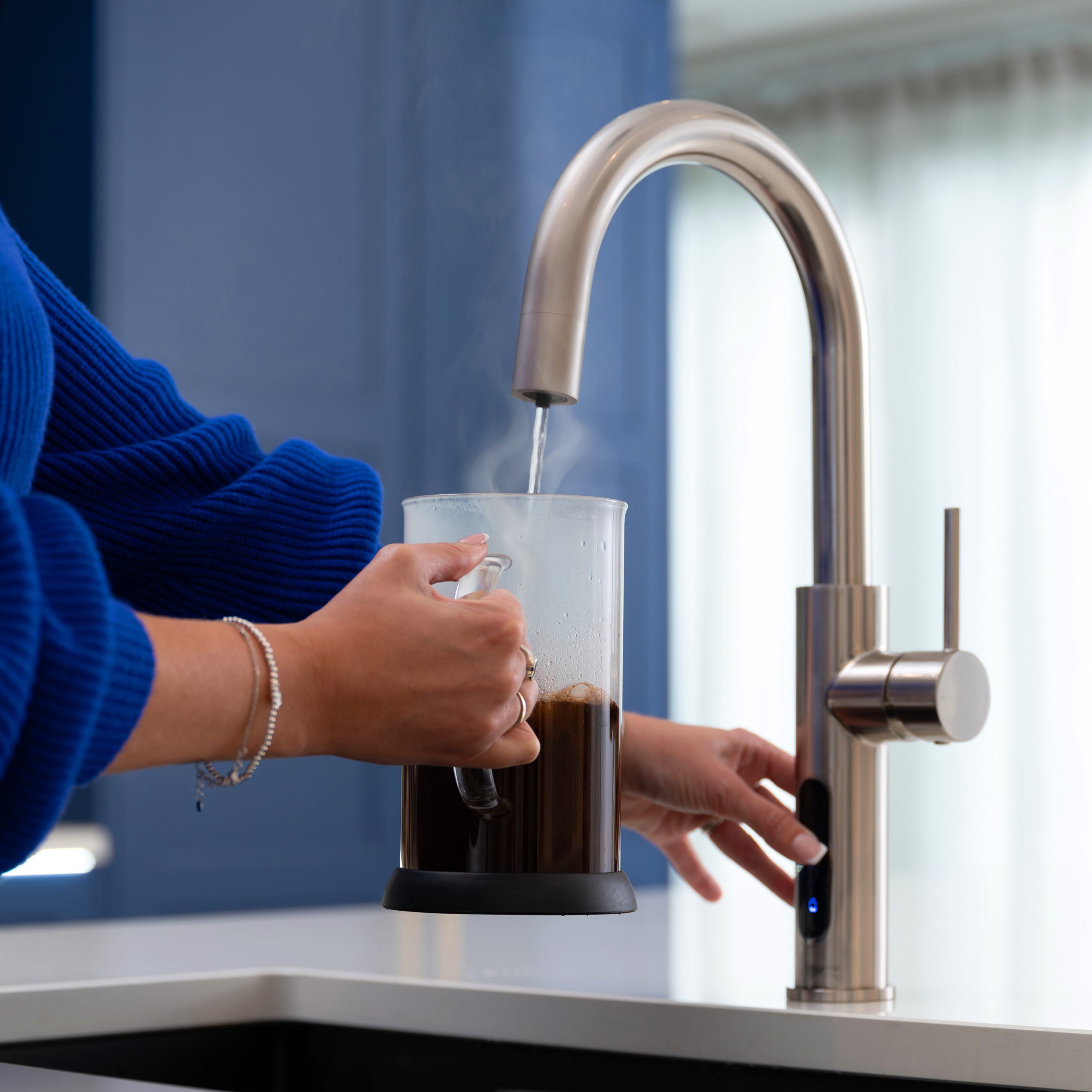 A Person Pouring Boiling Water From A Tap Into A Cafetiere