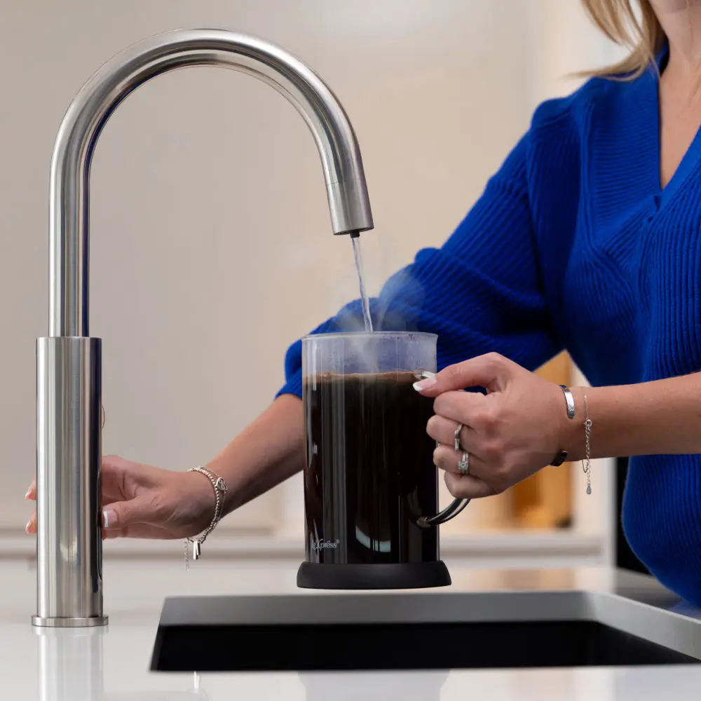 A Person Pouring Boiling Water From A Tap Into A Cafetiere